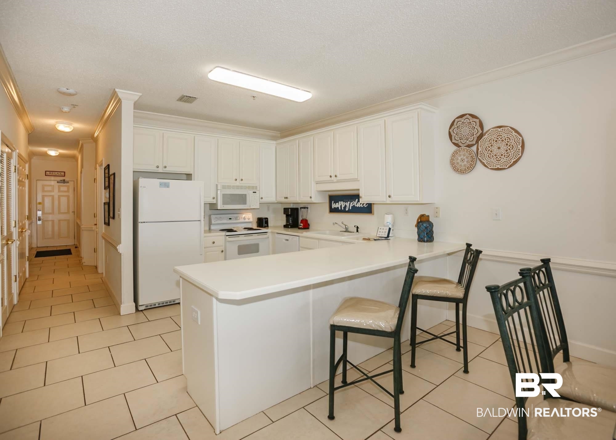 28910 Perdido Beach Boulevard, Unit 4B Orange Beach, AL 36561 - Photo 9 of 48 Kitchen featuring a sink, a kitchen bar, a peninsula, white appliances, and visible vents