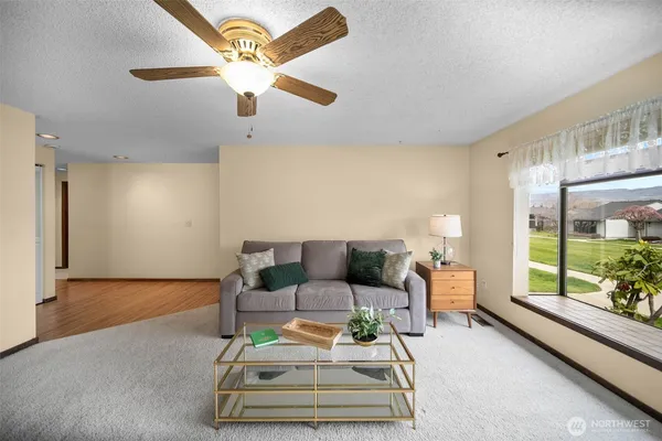 a living room with furniture and a floor to ceiling window