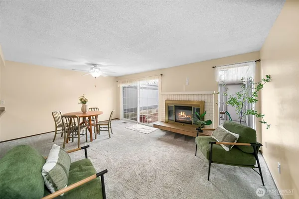 a living room with furniture a dining table and a fireplace