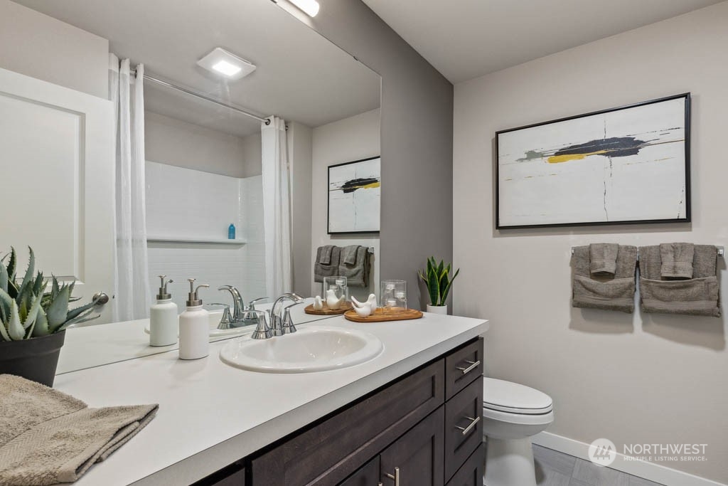 9614 19th Avenue Southeast, Unit E Everett, WA 98208 - Photo 16 of 17 a bathroom with a granite countertop sink and a mirror with toilet