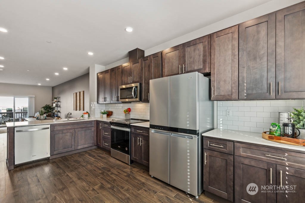 9614 19th Avenue Southeast, Unit E Everett, WA 98208 - Photo 8 of 17 a kitchen with granite countertop stainless steel appliances a refrigerator a sink and cabinets