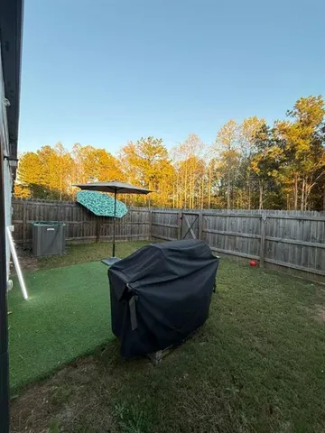 a view of a backyard with wooden fence