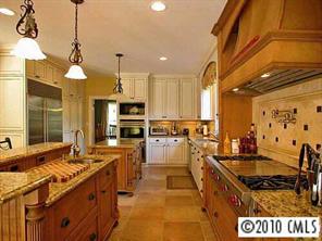 3901 Foxcroft Road Charlotte, NC 28211 - Photo 5 of 8 a kitchen with stainless steel appliances granite countertop a sink stove and refrigerator