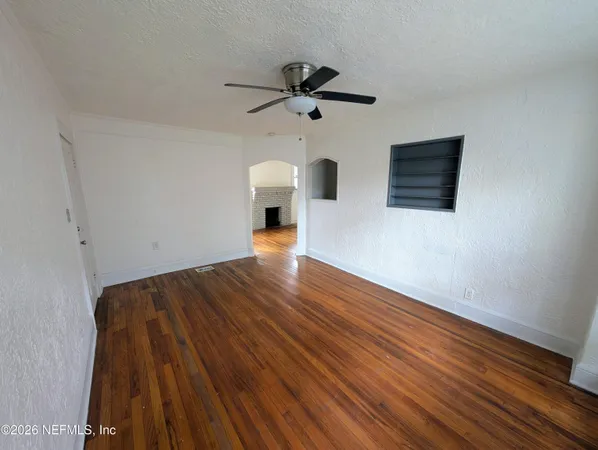 a view of empty room with wooden floor