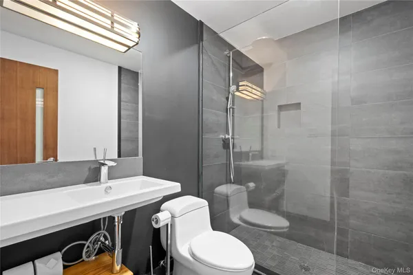 a bathroom with a sink a toilet and shower
