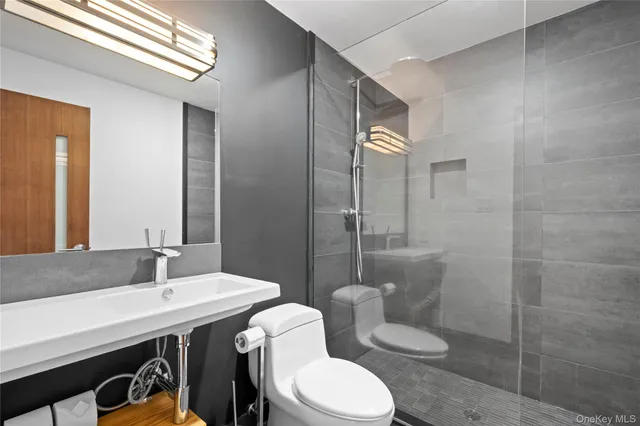 a bathroom with a sink a toilet and shower