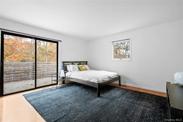 a bed sitting in a spacious bedroom next to a window