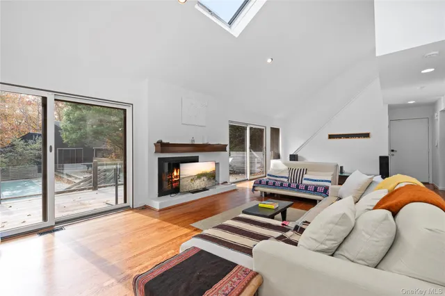 a living room with furniture a fireplace and a floor to ceiling window