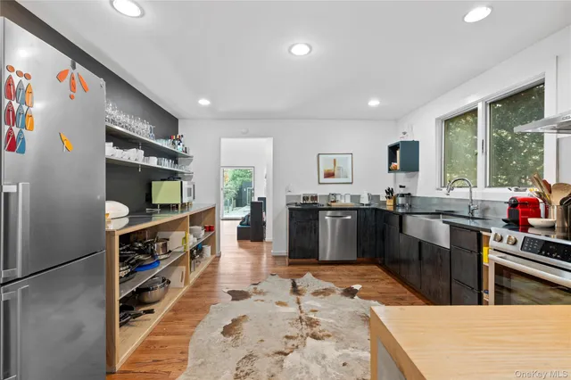 a kitchen with stainless steel appliances kitchen island granite countertop a refrigerator and a sink