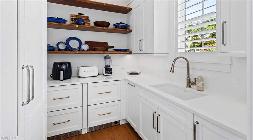 844 8th Street South Naples, FL 34102 - Photo 11 of 13 a kitchen with white cabinets and a wooden floor