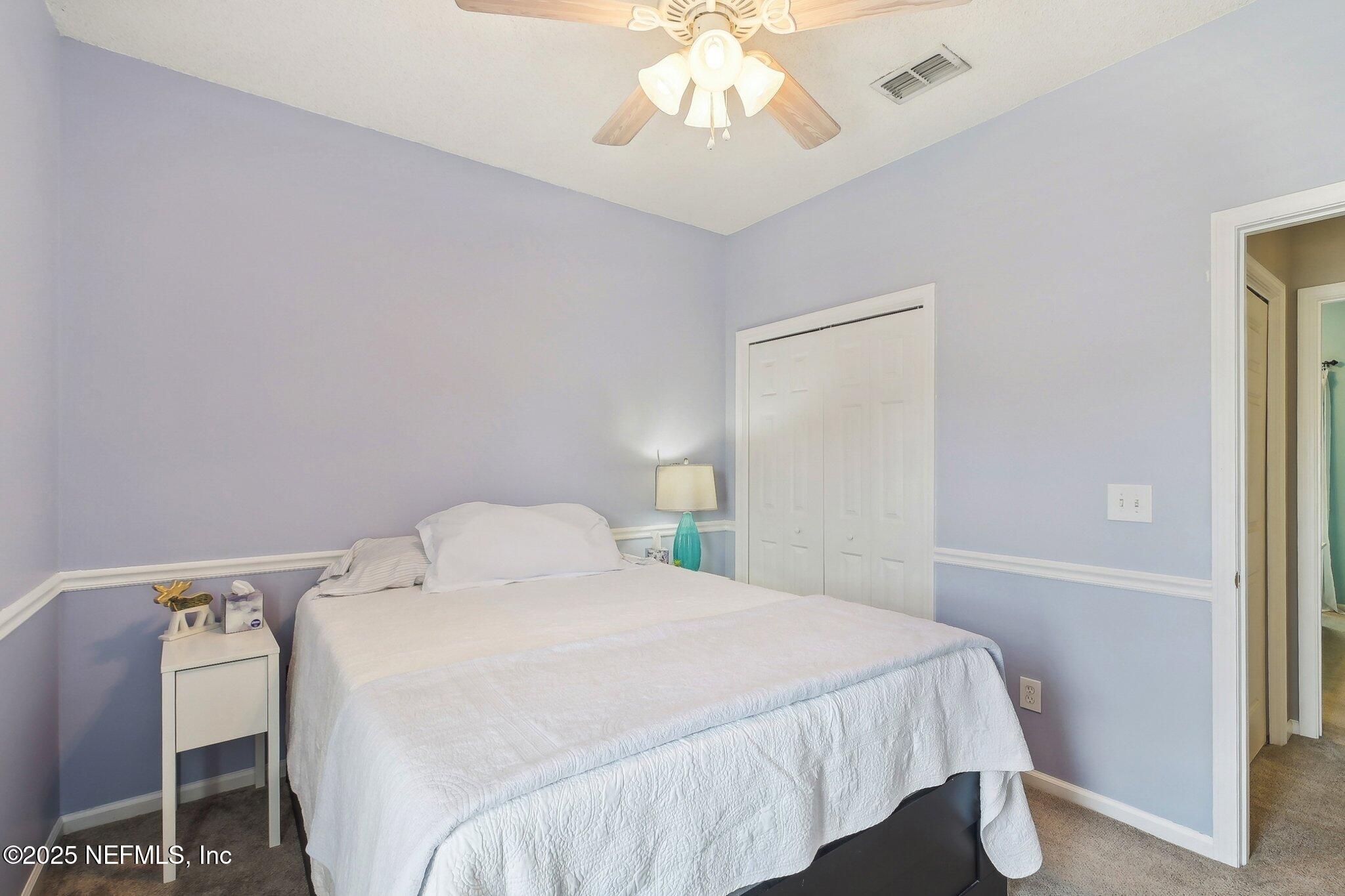 12529 Cliffrose Trail Jacksonville, FL 32225 - Photo 13 of 23 a bedroom with a bed and a chandelier