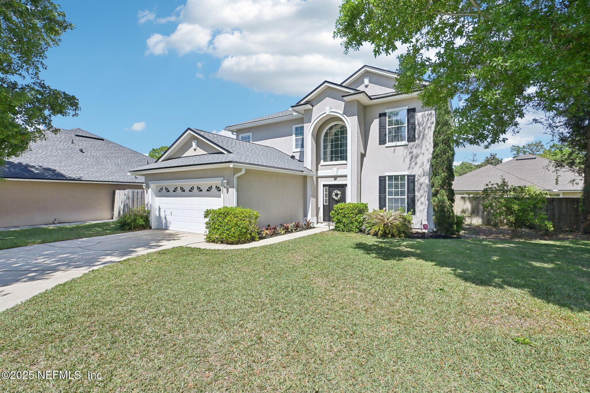 12529 Cliffrose Trail Jacksonville, FL 32225 - Photo 2 of 23 a front view of a house with a yard and garage