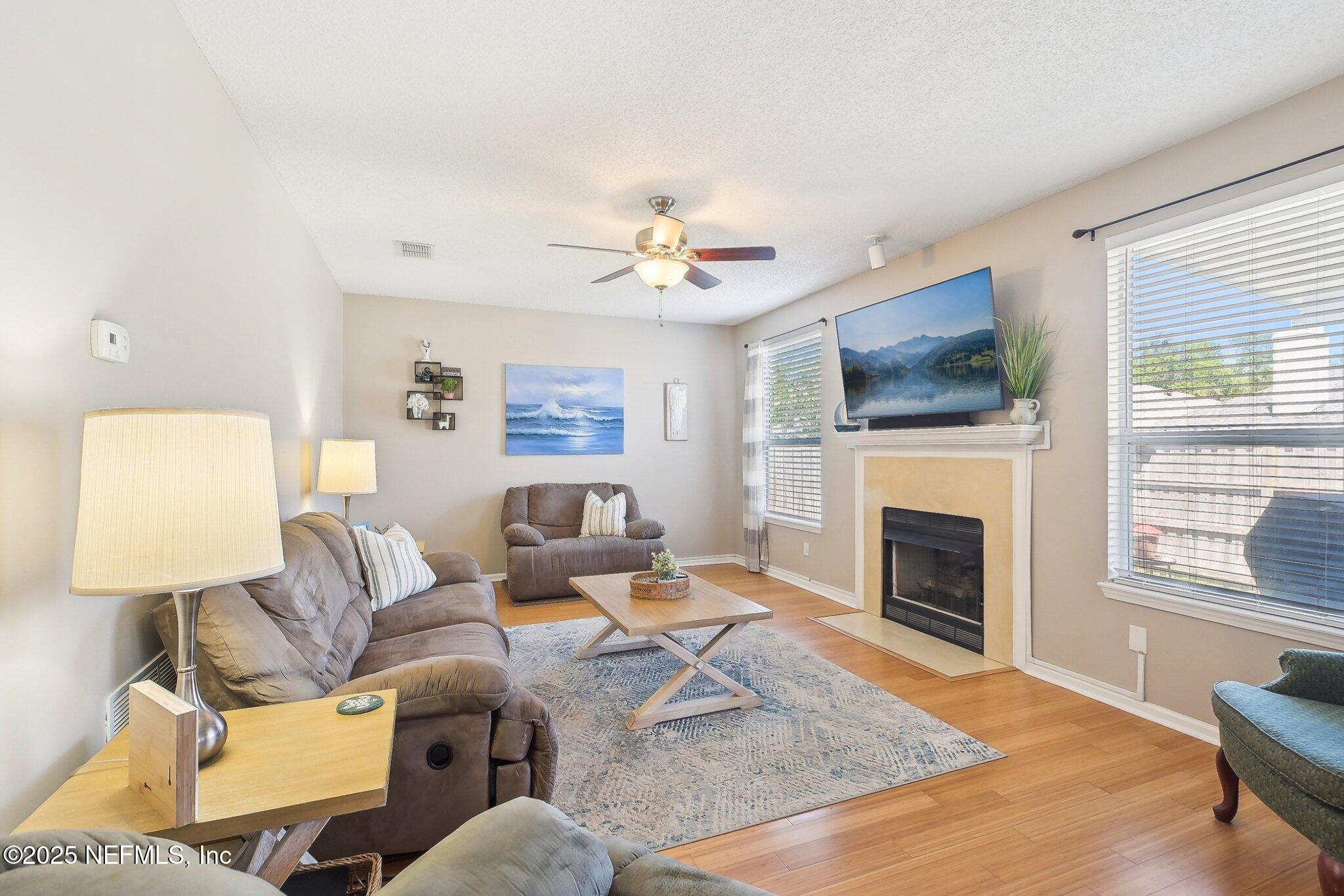 12529 Cliffrose Trail Jacksonville, FL 32225 - Photo 3 of 23 a living room with furniture a flat screen tv and a fireplace
