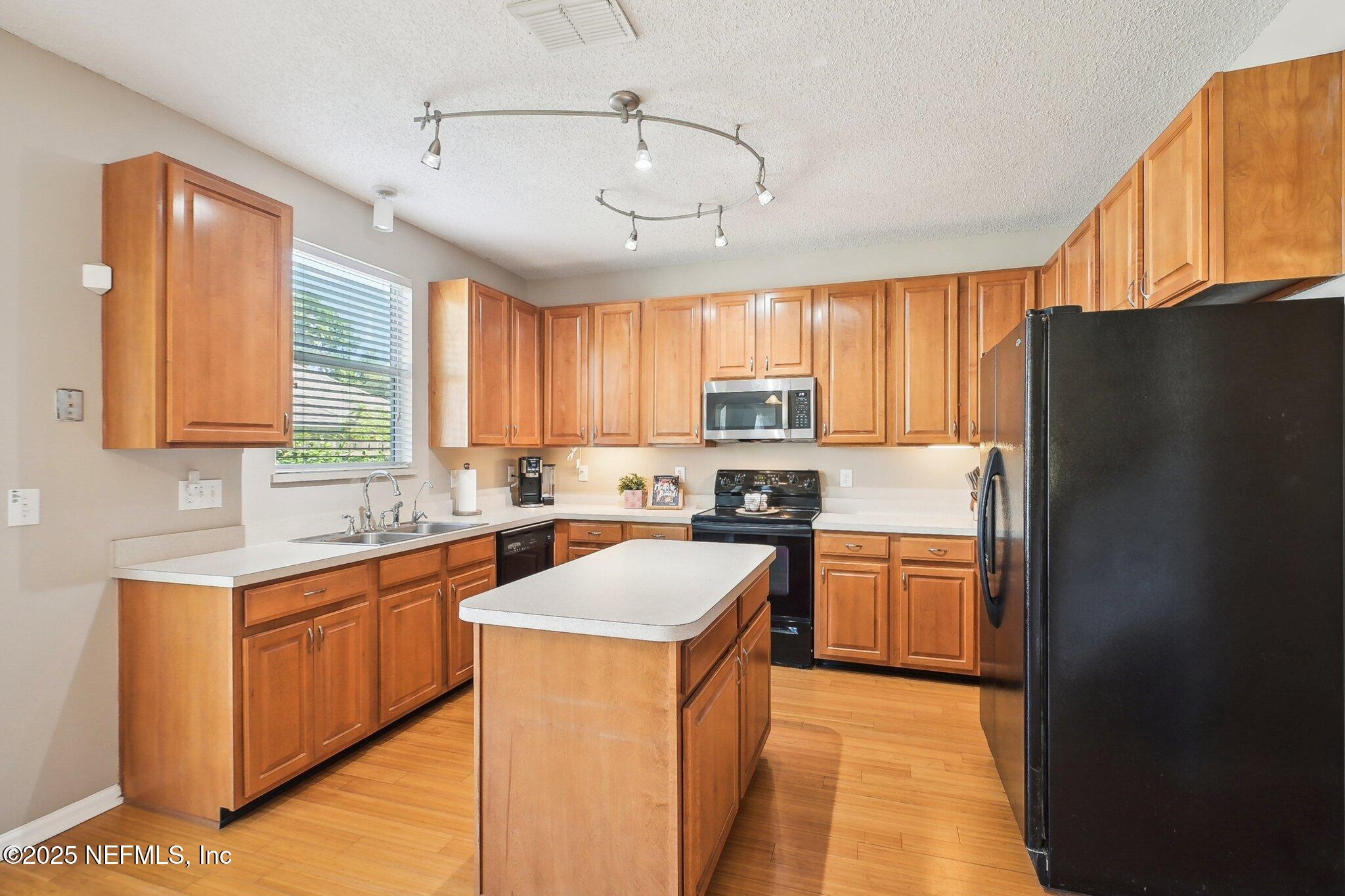 12529 Cliffrose Trail Jacksonville, FL 32225 - Photo 7 of 23 a kitchen with stainless steel appliances granite countertop a refrigerator a sink dishwasher a stove with wooden cabinets and a granite counter top