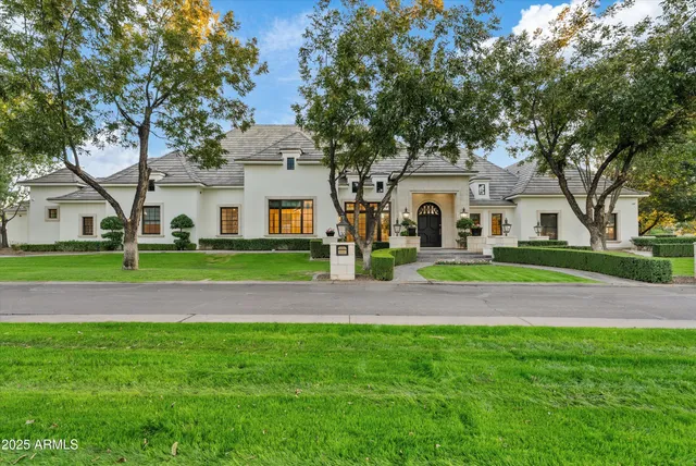 a view of a house with a big yard and large trees
