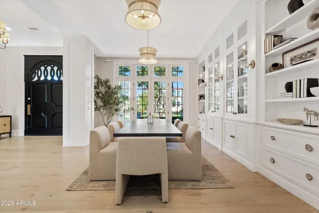 a dining room with couches chairs and large windows