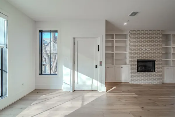 a view of an empty room with a fireplace and a window