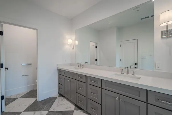 a bathroom with a double vanity sink and mirror
