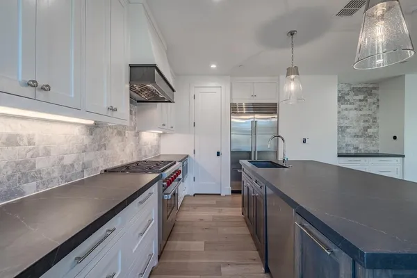 a kitchen with stainless steel appliances a sink stove and cabinets