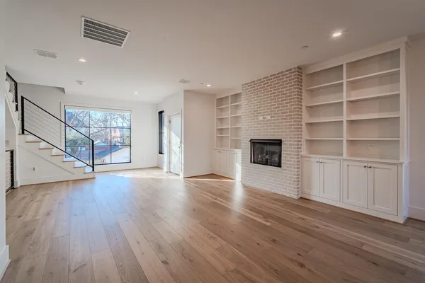 a view of an empty room with a fireplace and a window
