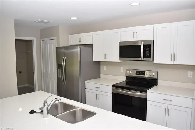 a kitchen with a sink and steel appliances