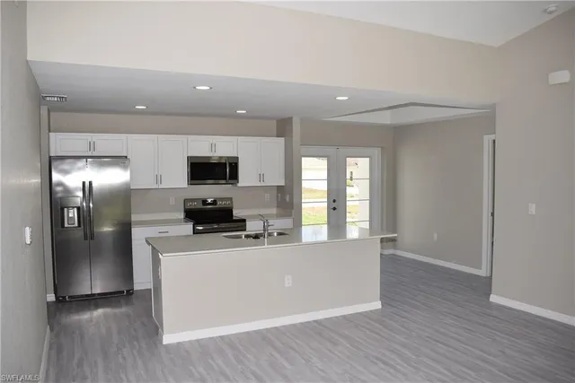 a view of a kitchen with a sink wooden floor and windows