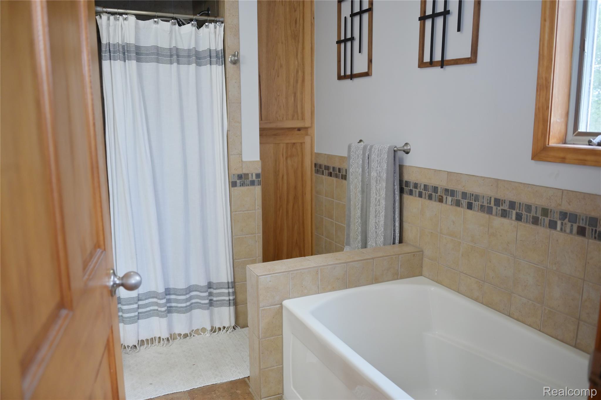 6950 Todd Road Croswell, MI 48422 - Photo 13 of 29 Bathtub with tile surround, wood-finish cabinetry, and a shower with a tiled enclosure