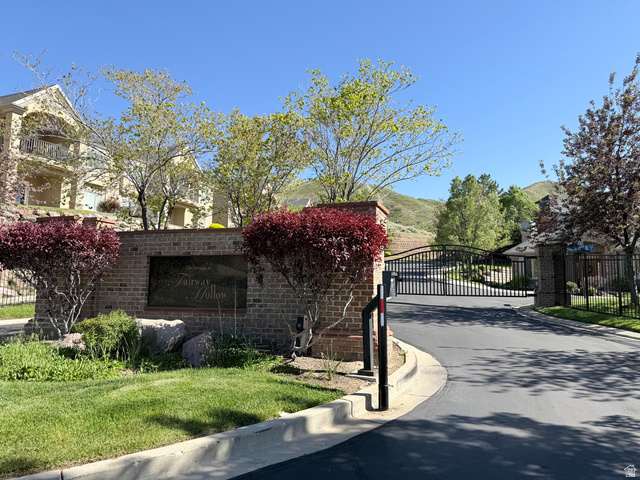 1562 Fairway Ridge Road Draper, UT 84020 - Photo 58 of 60 Gated community entrance featuring a brick monument sign, wrought iron gates, mature landscaping, and an asphalt driveway