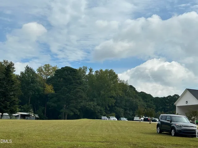 a view of car parked in middle of green field