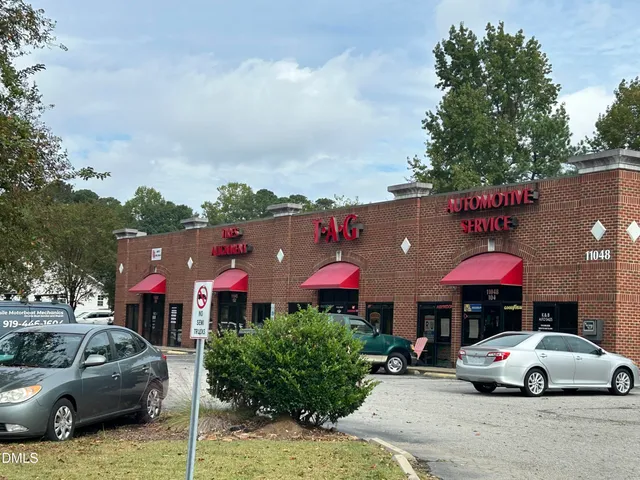 a front view of a house with a yard and car parked