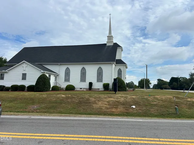 a front view of a house with a garden and plants