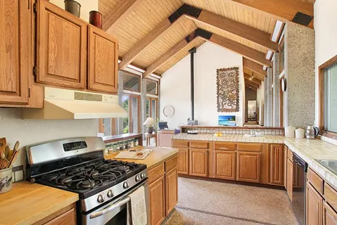 a kitchen with stainless steel appliances a stove a sink dishwasher and cabinets with wooden floor