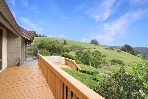 a view of balcony with wooden floor and fence