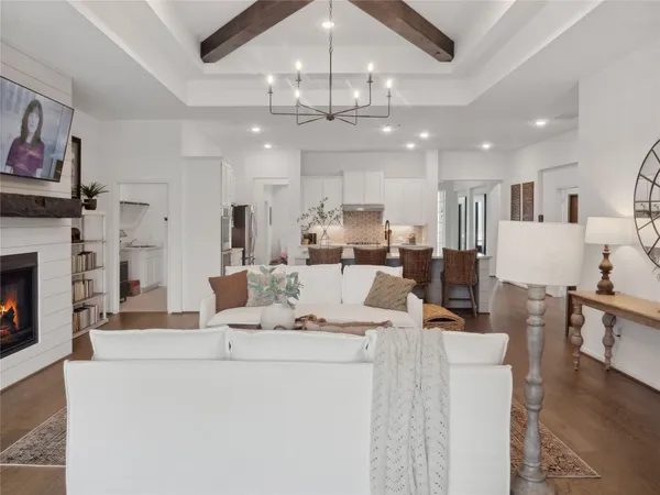 a living room with furniture a fireplace and kitchen view
