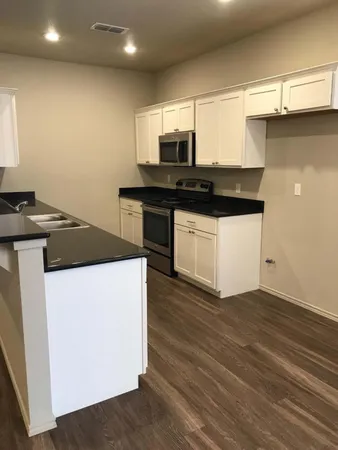 a kitchen with granite countertop a sink and a stove top oven