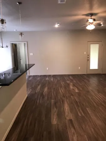 a view of a living room a ceiling fan and wooden floor