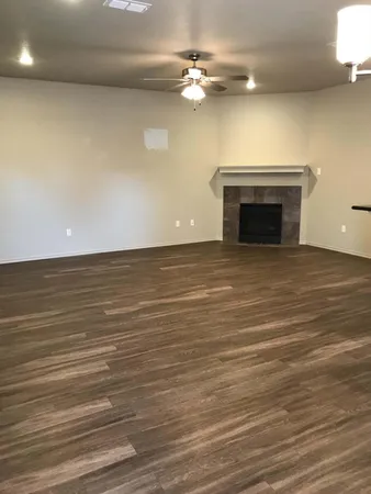 a view of an empty room with a fireplace and a fan