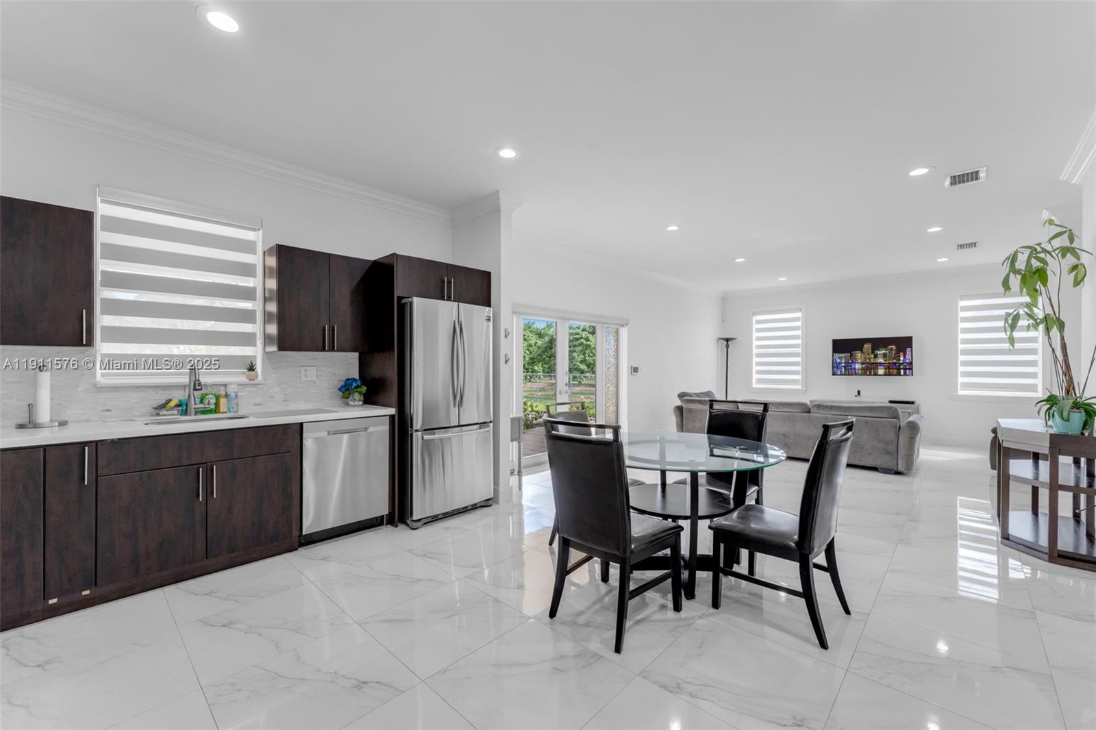 15050 Southwest 179th Avenue Miami, FL 33196 - Photo 35 of 46 a kitchen with a table chairs refrigerator and microwave