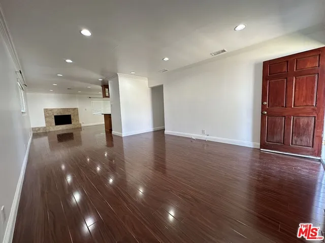 a view of an empty room with wooden floor
