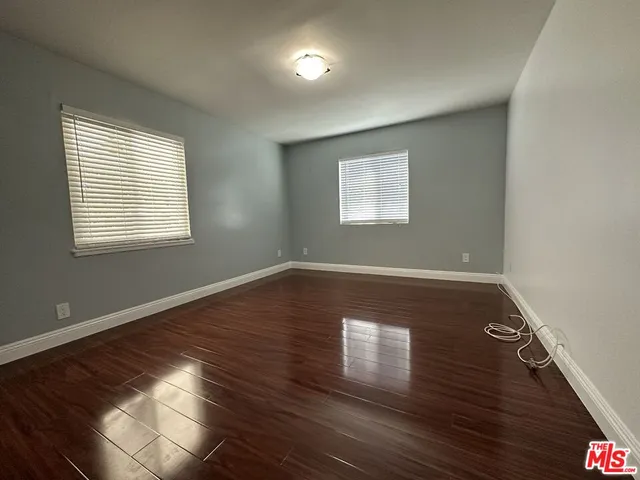 an empty room with wooden floor and closet