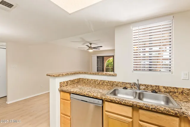 a bathroom with a granite countertop sink and a window