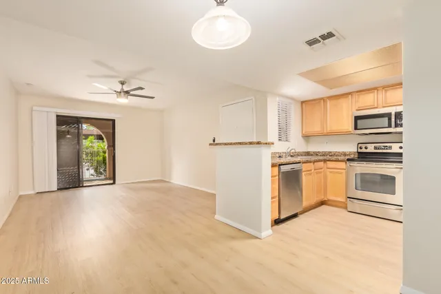 a view of kitchen with granite countertop cabinets and window