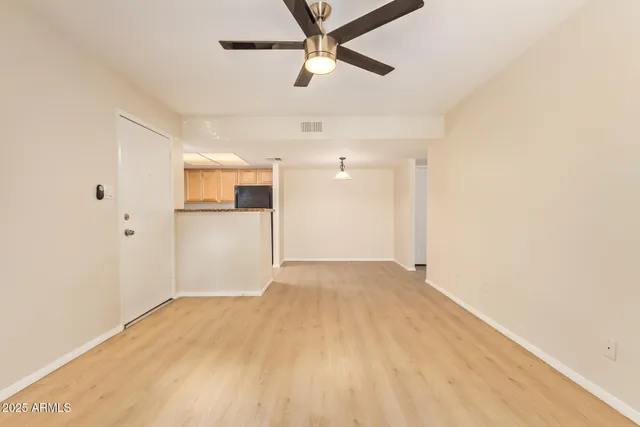 a view of a big room with wooden floor and a ceiling fan