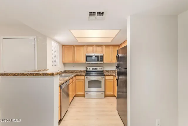 a kitchen with stainless steel appliances granite countertop a stove and a refrigerator