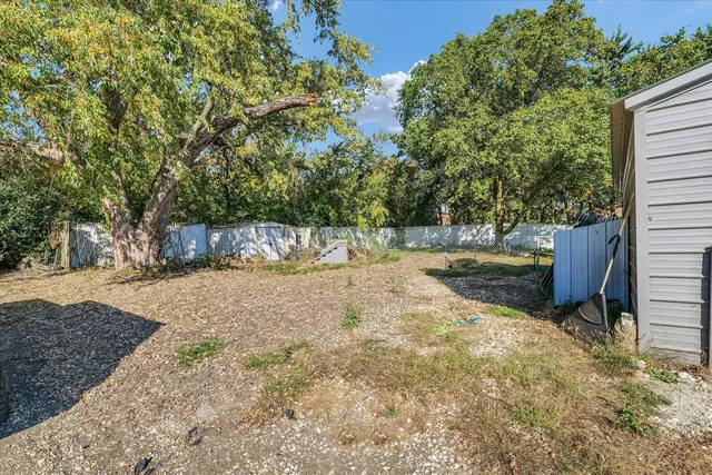 a view of a backyard with wooden fence