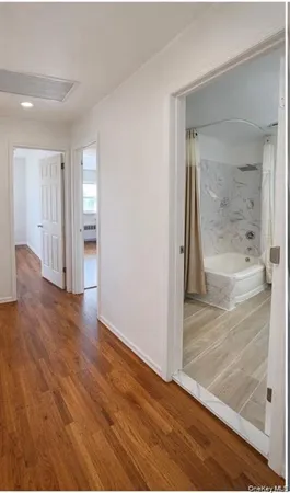 a view of a hallway with wooden floor