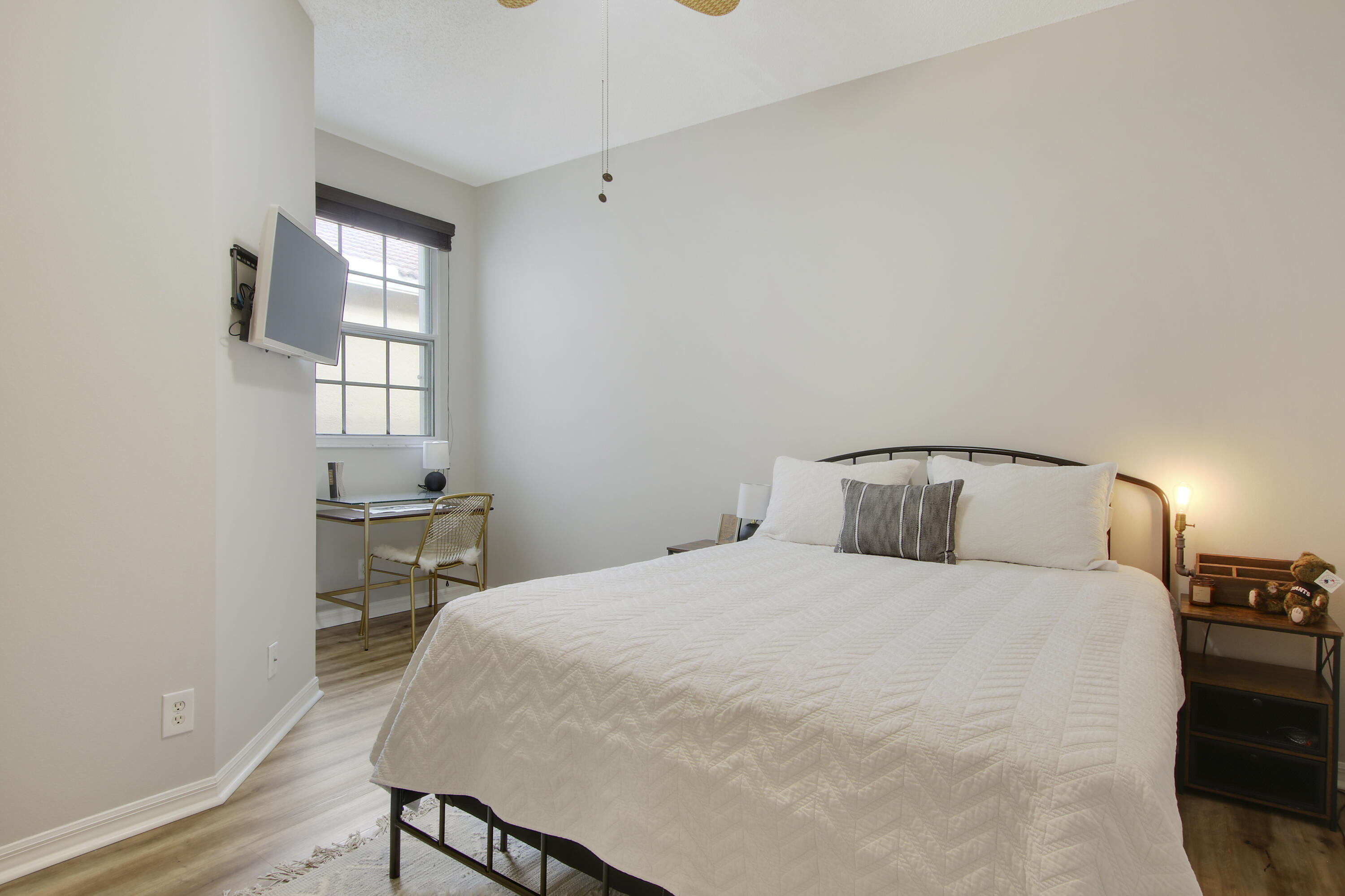 115 Lighthouse Circle, Unit D Tequesta, FL 33469 - Photo 20 of 28 a bedroom with a bed and a table in it