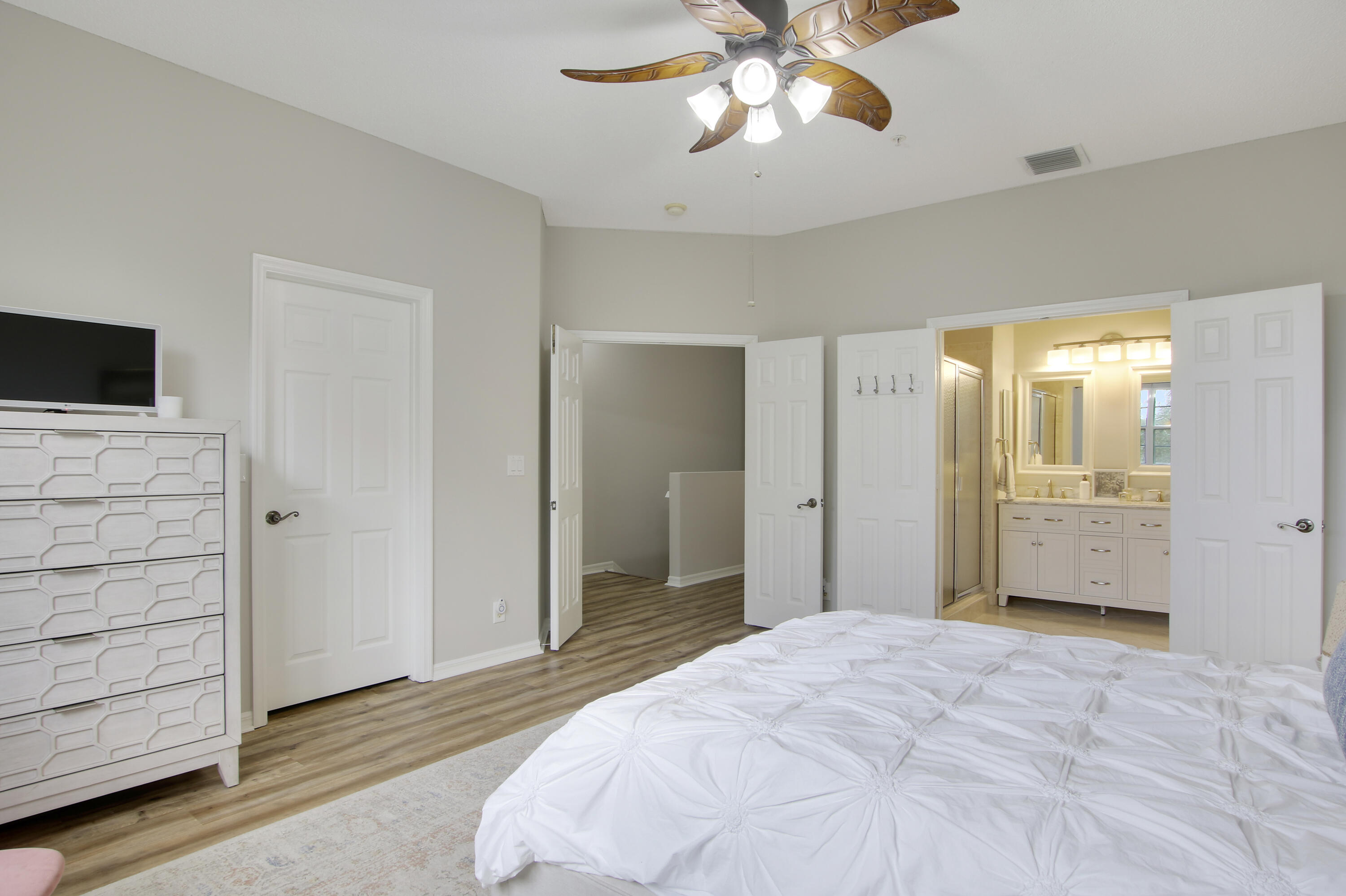 115 Lighthouse Circle, Unit D Tequesta, FL 33469 - Photo 22 of 28 a bedroom with a bed and a chandelier