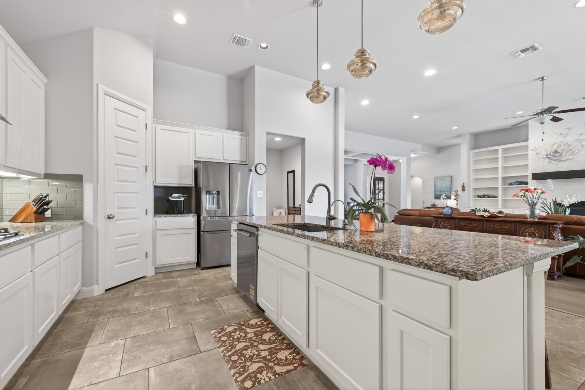 4105 Haight Street Round Rock, TX 78681 - Photo 15 of 40 Kitchen featuring white cabinetry, stainless steel appliances, a tile backsplash, and a large island with a stone countertop and undermount sink