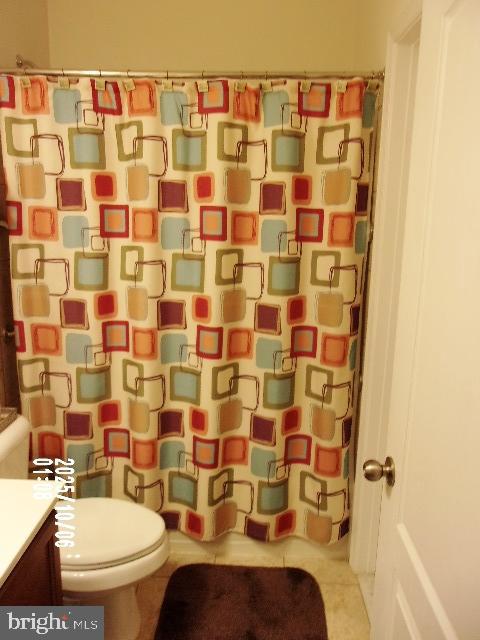 11612 Neon Road Fort Washington, MD 20744 - Photo 19 of 75 a bathroom with a toilet and a shower curtain